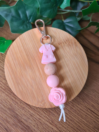 Our handmade keychains make the perfect gift for those amazing medical people in our lives. This keychain / zip puller comes with a pink scrub shaped bead.