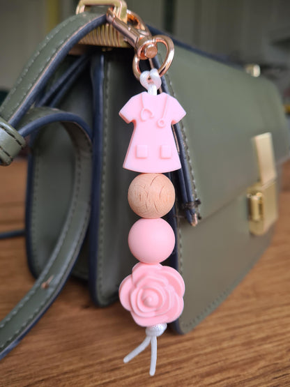 Our handmade keychains make the perfect gift for those amazing medical people in our lives. This keychain / zip puller comes with a pink scrub shaped bead.