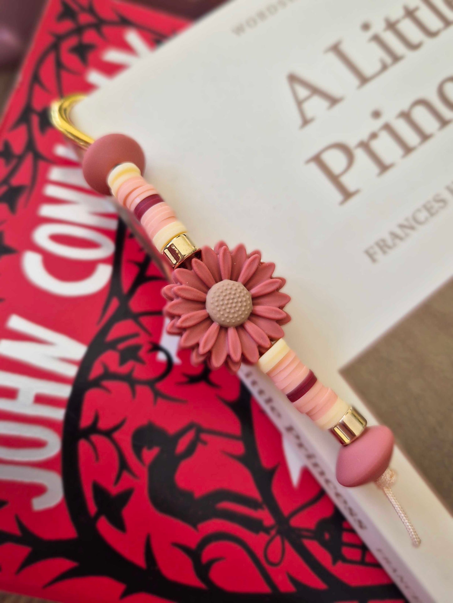 Gold feather bookmark decorated with beads. Floral bead as a central focal bead.