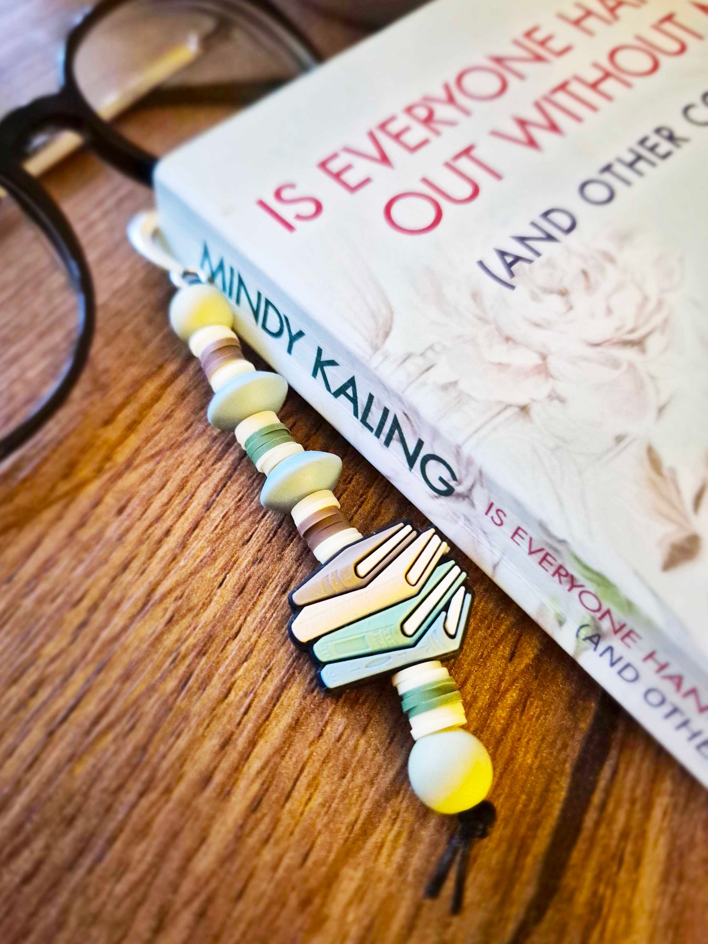 Silver feather bookmark decorated with beads. Stack of books as a focal bead.