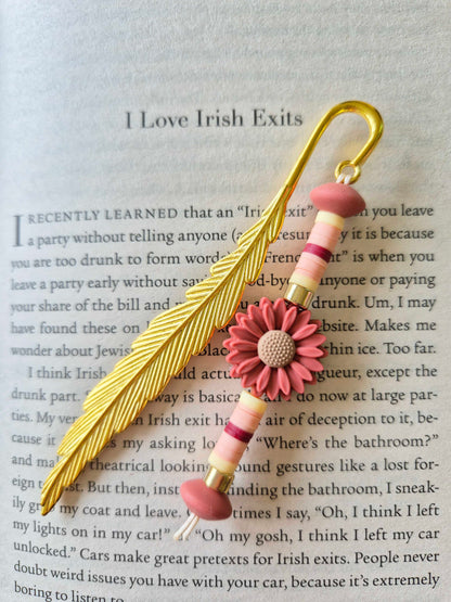 Gold feather bookmark decorated with beads. Floral bead as a central focal bead.