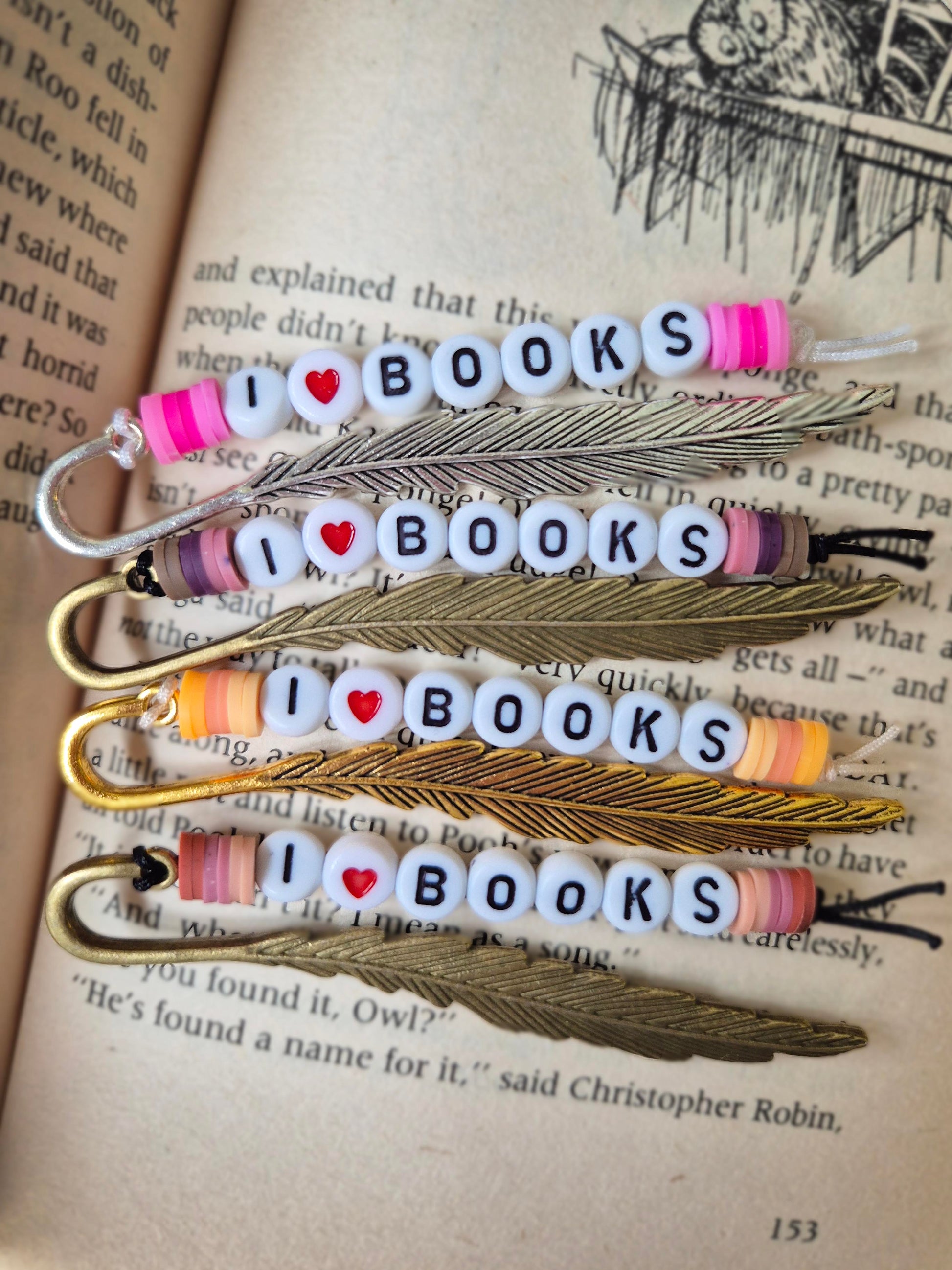 Mini feather bookmarks in silver, bronze and gold. Made with beads saying I ❤️ BOOKS