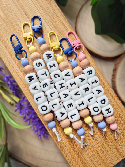 Six personalised keychains / bag charms. In pink blue and yellow colours with white letter silicone beads.