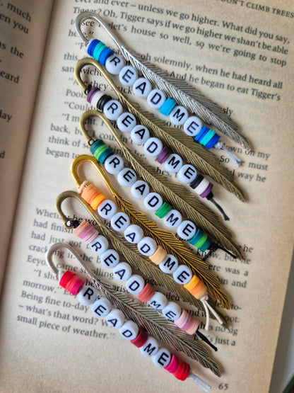 Mini feather bookmarks in silver, bronze and gold. Made with beads saying READ ME