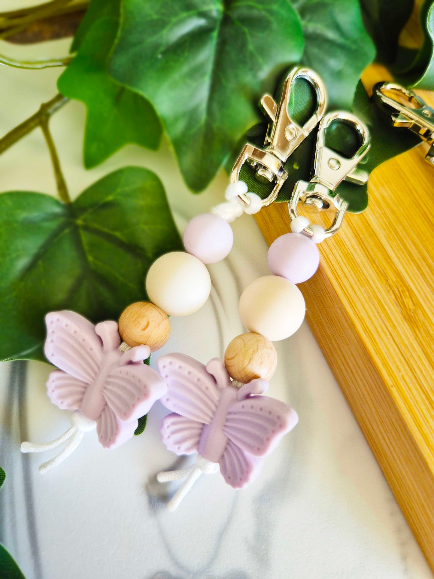 Keychain / Bag Decor / Zip Puller made of beech wood and silicone beads. Silver clip with lilac butterfly as a focal bead.