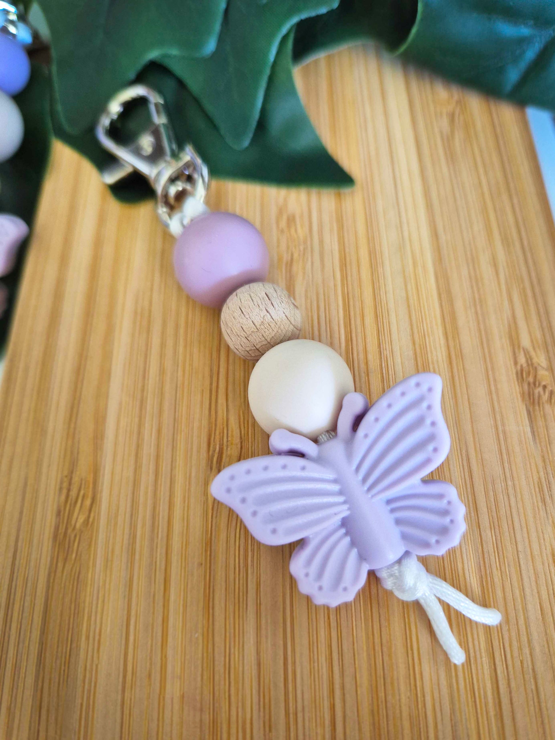 Keychain / Bag Decor / Zip Puller made of beech wood and silicone beads. Silver clip with lilac butterfly as a focal bead.