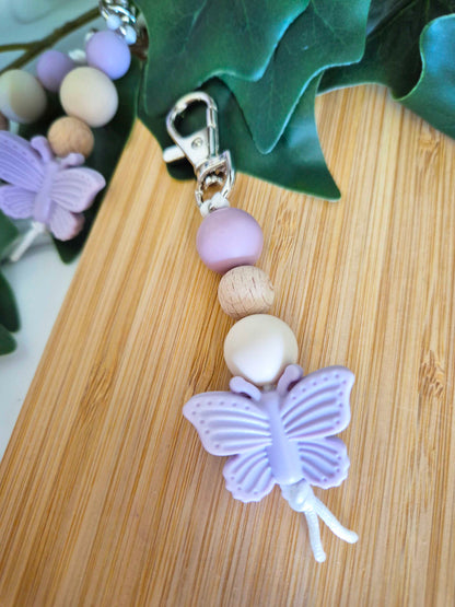 Keychain / Bag Decor / Zip Puller made of beech wood and silicone beads. Silver clip with lilac butterfly as a focal bead.