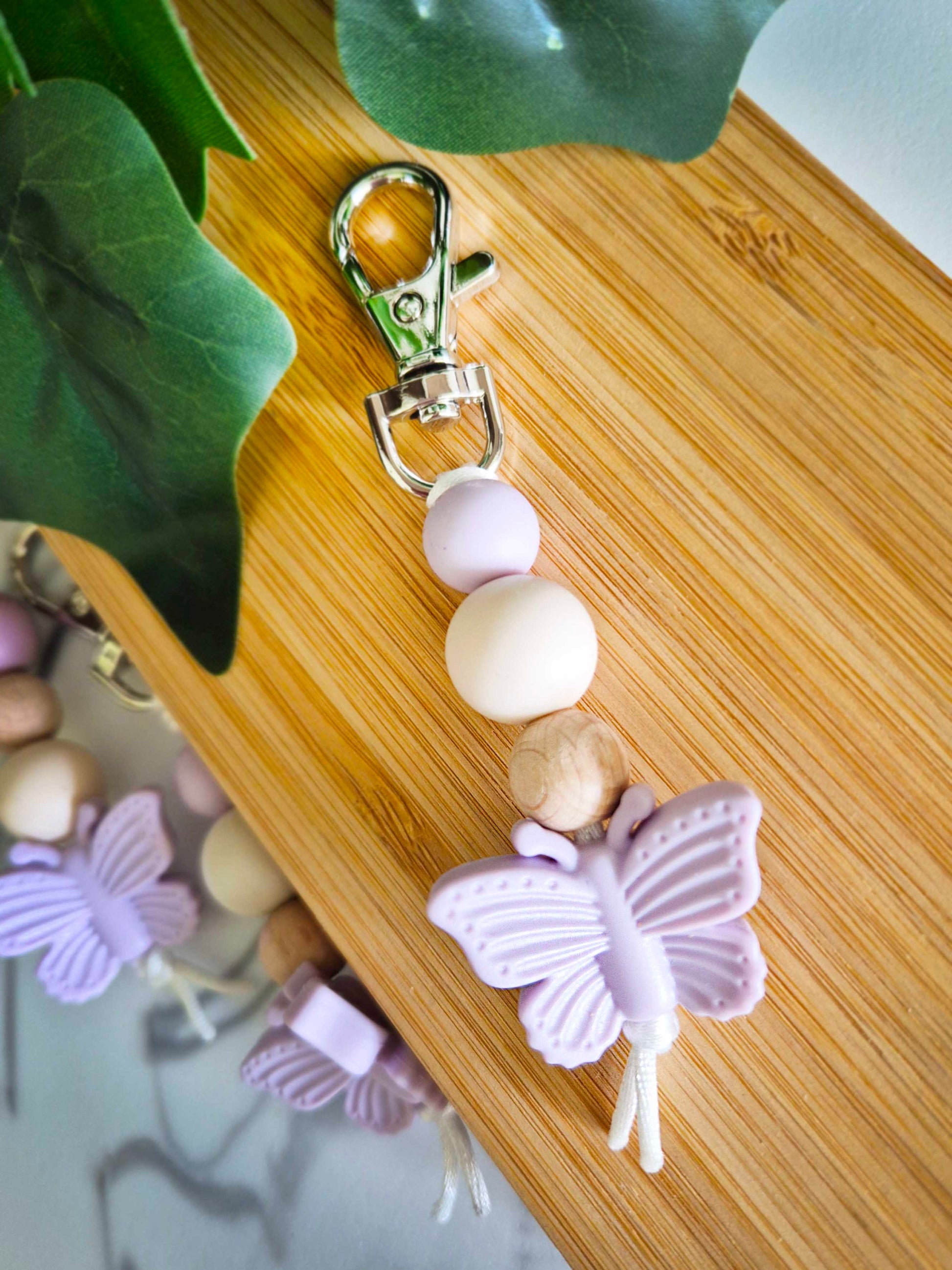 Keychain / Bag Decor / Zip Puller made of beech wood and silicone beads. Silver clip with lilac butterfly as a focal bead.